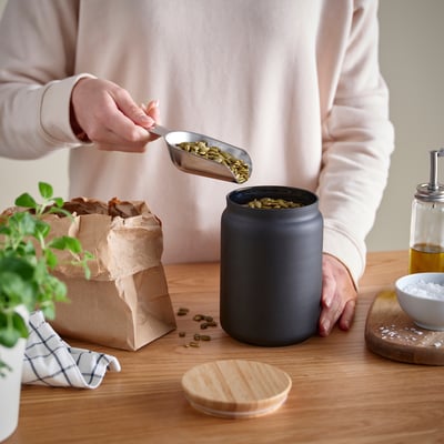 EKLATERA: barattolo cilindrico nero per alimenti con coperchio in legno. Forma rotonda, piano in bambù, corpo in vetro.