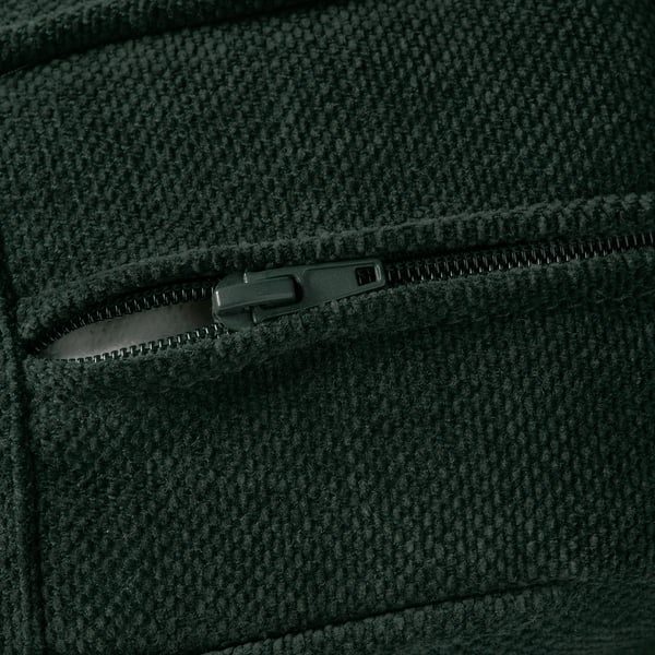 Un primo piano in tessuto verde scuro, che mostra una cerniera resistente e materiale testurizzato.