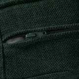 Un primo piano in tessuto verde scuro, che mostra una cerniera resistente e materiale testurizzato.