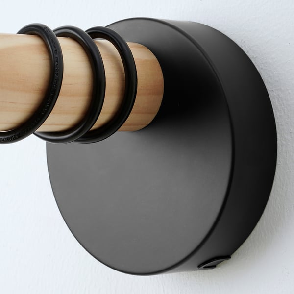 Lampada da parete moderna con dettagli in legno e metallo nero, che mostra una lavorazione artigianale di qualità.