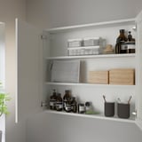 Mobile bagno aperto con ante a specchio, che espone articoli da toeletta e contenitori ben organizzati.