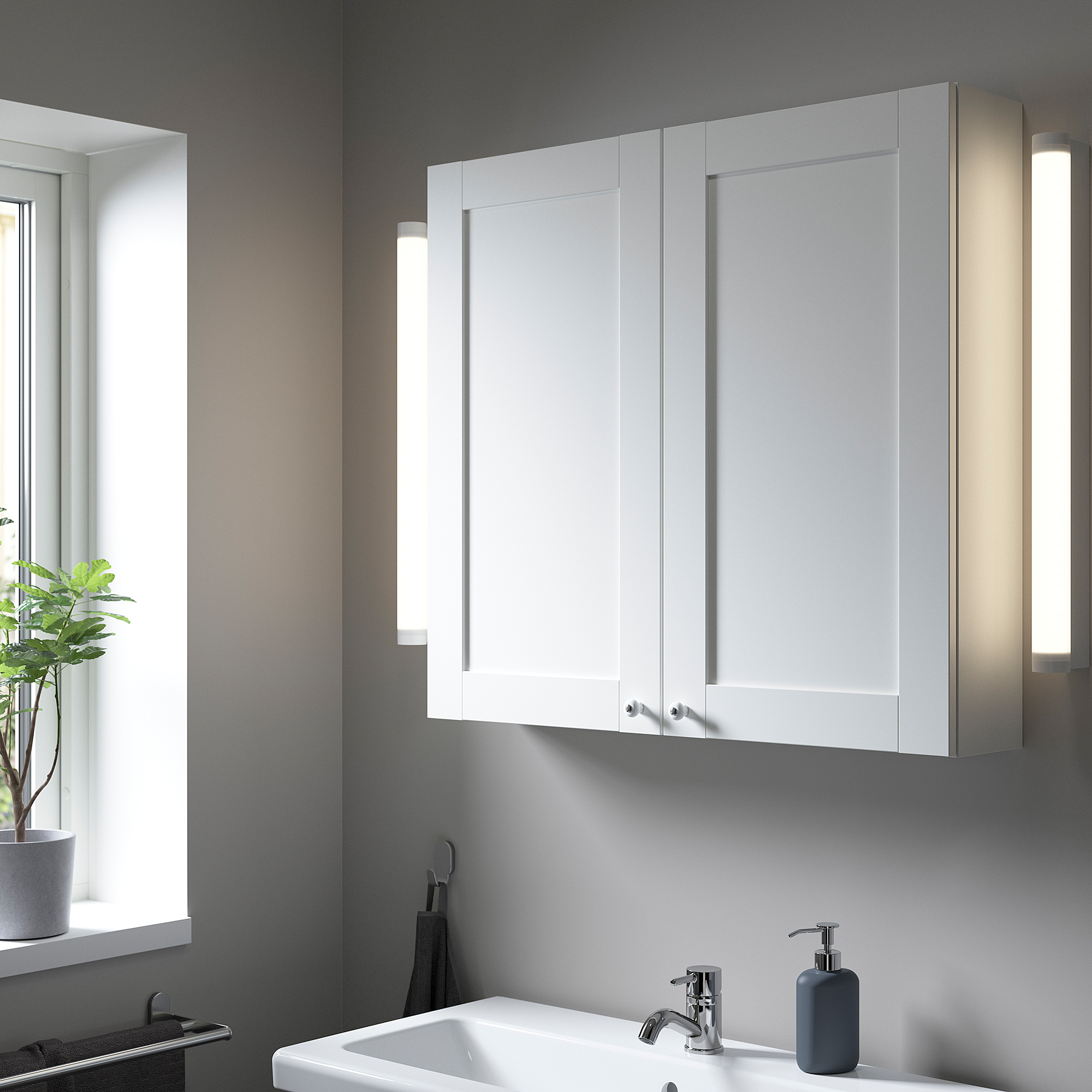 Pensile ENHET sopra il lavandino in bagno con luci e piante.
