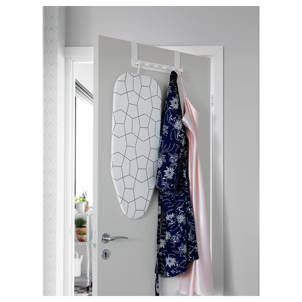 L'appendiabiti bianco sopra la porta con design esagonale contiene i vestiti.
