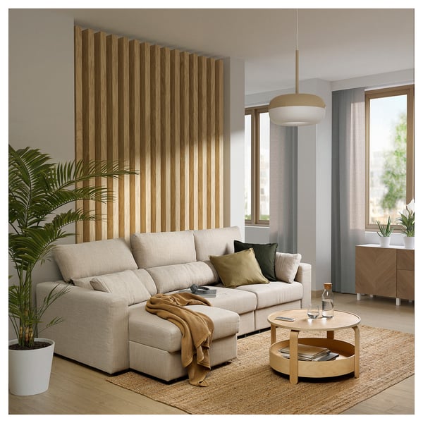 Soggiorno moderno con divano ESKILSTUNA beige, accenti in legno e ampia finestra.