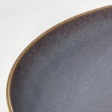 Ciotola smaltata blu, primo piano su bianco.