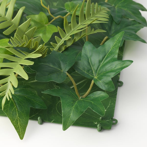 Pannello vegetale artificiale con foglie verdi vivaci, fissato a una robusta cornice, perfetto per l'arredamento della casa.