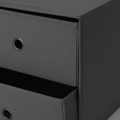 Piccola cassettiera grigia con due cassetti, uno con maniglia e l'altro aperto, che mostra tessuti e costruzione di buona qualità.