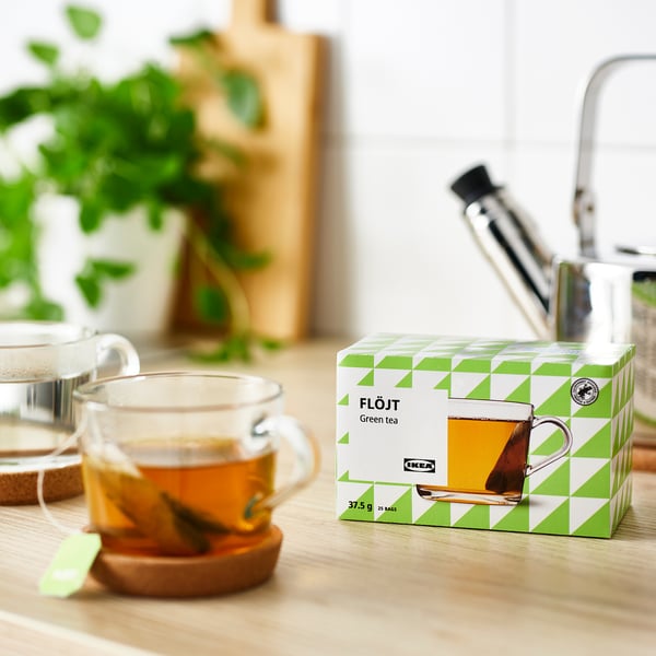 Scatola di bustine di tè verde sul tavolo vicino alla tazza da tè.