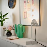 Scrivania moderna con lampada FLOTTILJ, decorazioni a cactus e fiori.