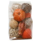 Sacchetto trasparente contenente zucche arancioni e sfere intrecciate beige, pot-pourri decorativi a tema autunnale.