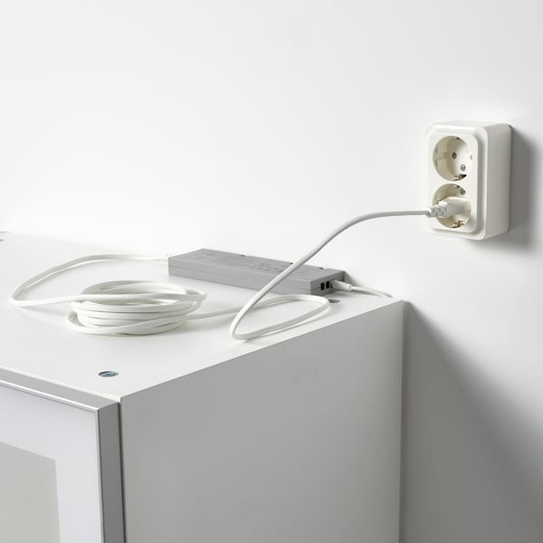 Adattatore di alimentazione bianco collegato alla presa, che fornisce alimentazione alle strisce led per l'illuminazione.