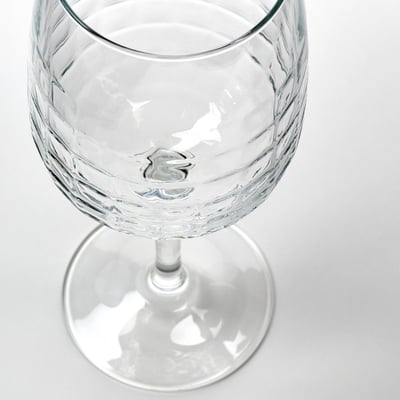 Bicchiere trasparente con motivi strutturati dettagliati, elegantemente progettato per vino o cocktail.