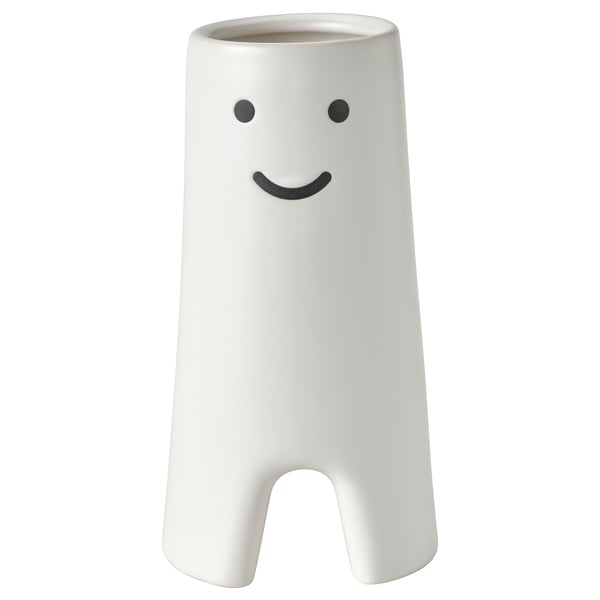 Vaso in ceramica bianca con disegno del volto sorridente, forma cilindrica con piccoli ritagli alla base.
