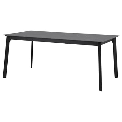 Un tavolo da pranzo allungabile GILLANDA con piano grigio scuro, effetto pietra, ed eleganti gambe in metallo nero. Design moderno e minimalista.