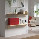 Soggiorno moderno con mensole in legno, scatole di velluto rosso, decorazioni e divano con cuscini.