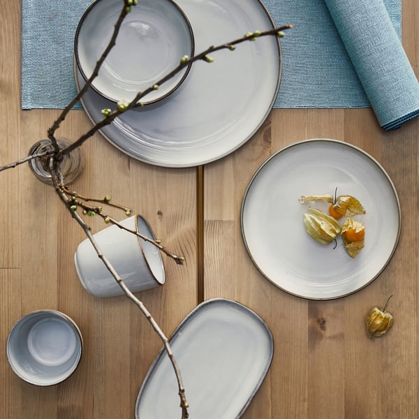 Servizio da tavola GLADELIG in azzurro su tavolo in legno con piatti e tazza.