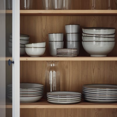 GLADELIG: set di piatti in gres smaltato grigio, di varie dimensioni, impilati ordinatamente.