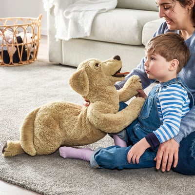 Giocattolo per cani in peluche dorato, beige con macchie marroni, morbido e sdraiato.