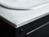 Un bordo del lavello in argento metallizzato con gocce d'acqua su una base nera.