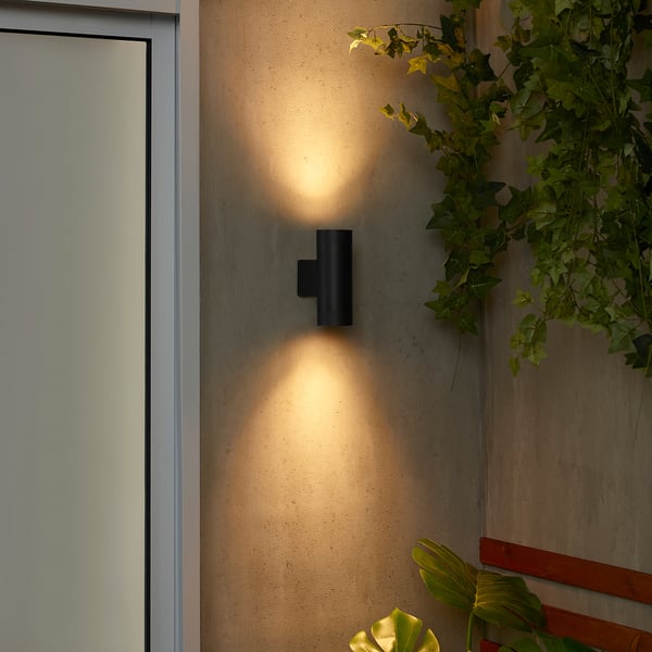 La lampada da parete nera GRÖNSPRÖT illumina la parete. Design elegante e compatto; emettendo luce calda. Circondato da piante; più piccolo della porta adiacente.