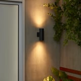 La lampada da parete nera GRÖNSPRÖT illumina la parete. Design elegante e compatto; emettendo luce calda. Circondato da piante; più piccolo della porta adiacente.