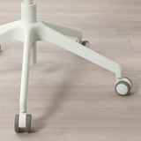 Base ergonomica della sedia: robuste gambe bianche, ruote nere lisce, design elegante e minimale.