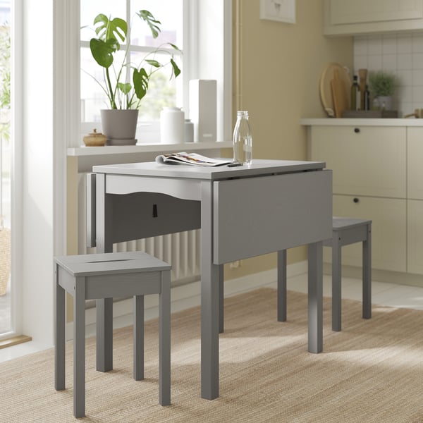 Accogliente configurazione della cucina con tavolo e sgabelli grigi HAUGA. Design in legno, salvaspazio e dal look moderno, perfetto per piccoli spazi.
