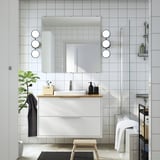 Vanità moderna, HAVBÄCK, con bancone in bambù e lavabo semi-incasso, montaggio a parete, grande specchio con luci, piastrelle bianche della metropolitana, doccia in vetro.