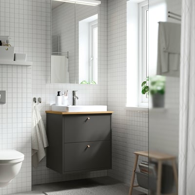 Bagno moderno con lavabo ikea grigio, lavandino bianco, bancone in legno, specchio, sgabello, asciugamani, pianta, minimalista.
