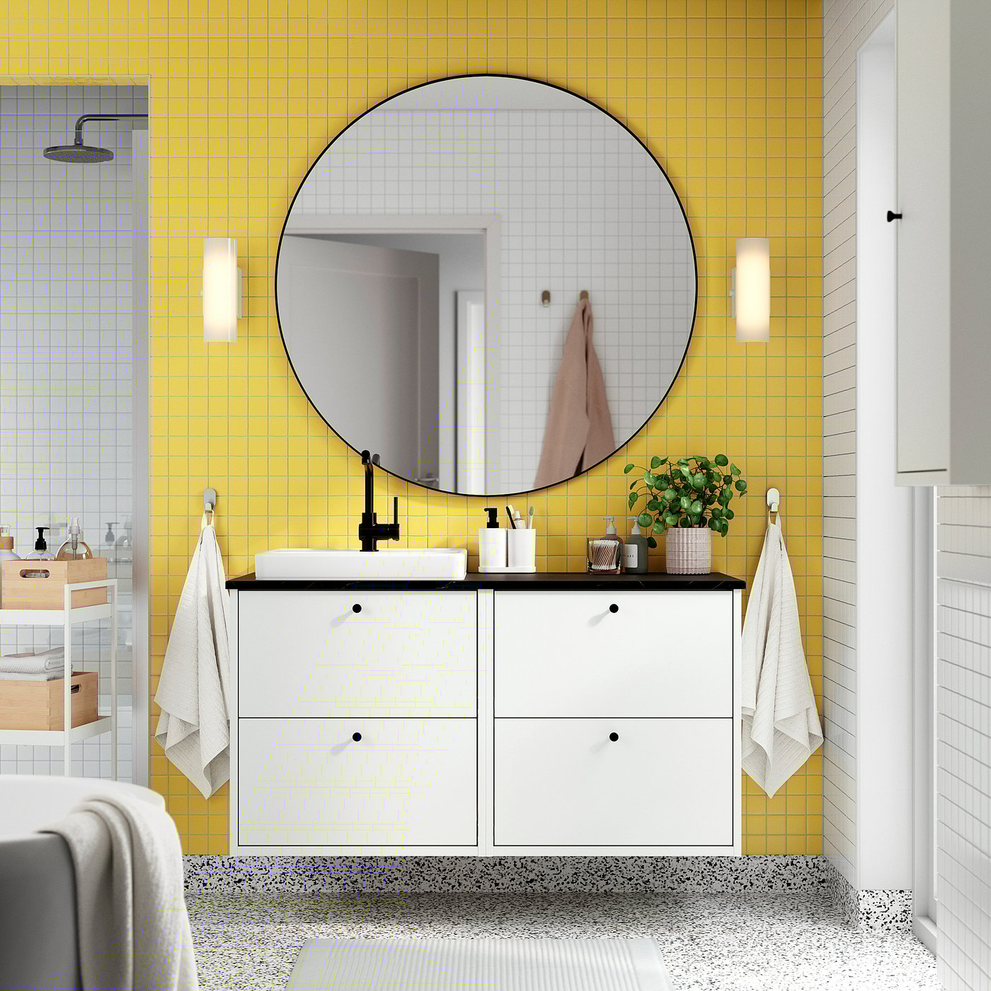 Bagno moderno con lavabo HAVBÄCK, parete piastrellata gialla, grande specchio e ripostiglio.