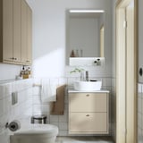 Bagno minimalista con lavabo HAVBÄCK, lavandino, specchio, asciugamani e piante.