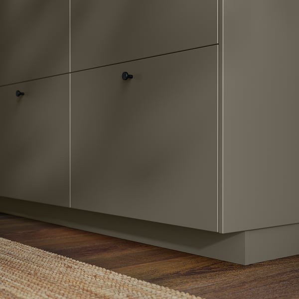 Mobili da cucina bassi in grigio scuro con maniglie blu su pavimento in legno.
