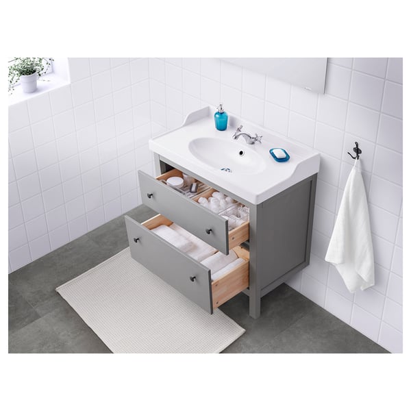 Bagno piccolo e ordinato con un lavabo grigio HEMNES dalle linee pulite con cassetti scorrevoli, un lavandino bianco e un pratico contenitore.