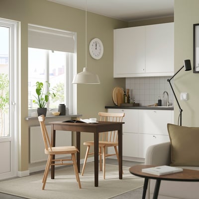 La sedia HÖGVED, una sedia in legno chiaro con finitura naturale, schienale a fuso e seduta curva, emana un design classico ed elegante.