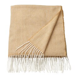 Una coperta HOLMVI beige-gialla con bordi sfrangiati, realizzata in morbido poliestere ecologico.