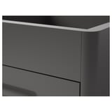 Primo piano dell'elegante cassettiera grigio scuro con bordi lisci, che mostra un design moderno e finiture di alta qualità.