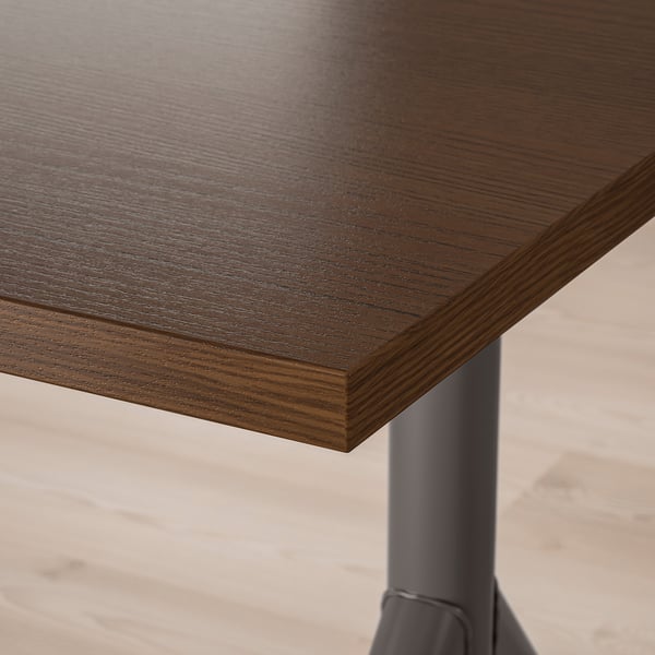 Un primo piano di un tavolo in legno scuro con venature fini visibili e una finitura liscia ed elegante.