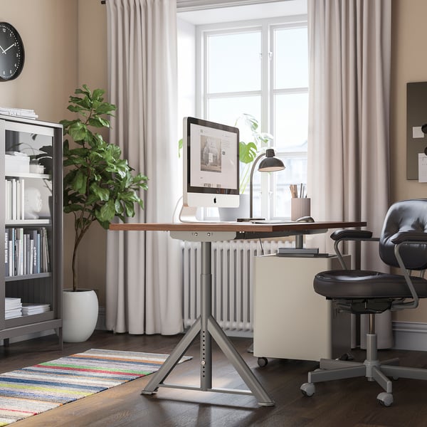 Home office con scrivania, sedia e grande finestra IDÅSEN con tende e tappeto.