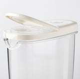 Barattolo per alimenti in plastica trasparente con coperchio ribaltabile bianco, progettato per la conservazione di alimenti secchi. Trasparente per una facile visibilità.