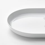 Un piatto da portata rotondo in porcellana incontaminata con una finitura liscia e lucida e un bordo leggermente rialzato, che dimostra un'alta qualità artigianale.