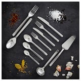 Set di posate in acciaio inox lucido di IKEA 365+ su una superficie scura con spezie.