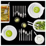 Set di posate IKEA 365+; acciaio inossidabile; design minimalista; include cucchiaio, forchetta e coltello; disposti ordinatamente su sfondo nero.
