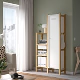 Armadio IVAR bianco vicino alla finestra, con libri e lampada. Acciaio e pino, arredamento moderno e minimalista.