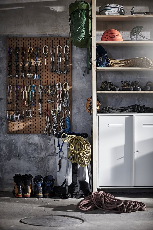 Garage con deposito IVAR - ripiani marroni, armadio bianco, attrezzatura da arrampicata.