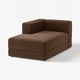Divano marrone a forma di L con texture a costole, design moderno e spazio per riporre.
