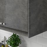 Mobile da cucina grigio con pianta e distributore di olio sotto.