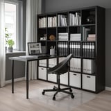 Home office: mensola KALLAX, scrivania, sedia, finestra con pianta.