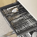 Lavastoviglie aperta che mostra utensili organizzati su più livelli, dimostrando la sua capacità di archiviazione spaziosa e regolabile.