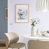 Vaso minimalista KAPKASTANJ con texture scanalata, che tiene fiori bianchi sul tavolo da pranzo con sedie.