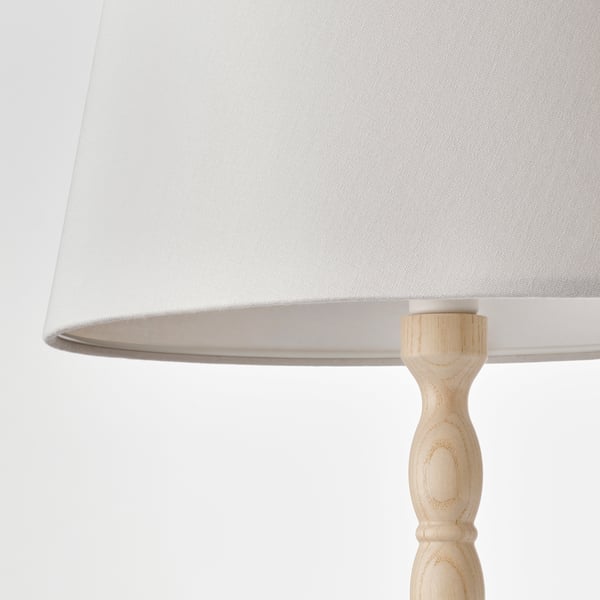 Lampada minimalista con paralume bianco e base in legno naturale. Realizzato con cura, mette in mostra dettagli raffinati.